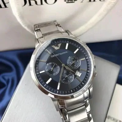 A silver chronograph watch with a dark dial, worn on a wrist