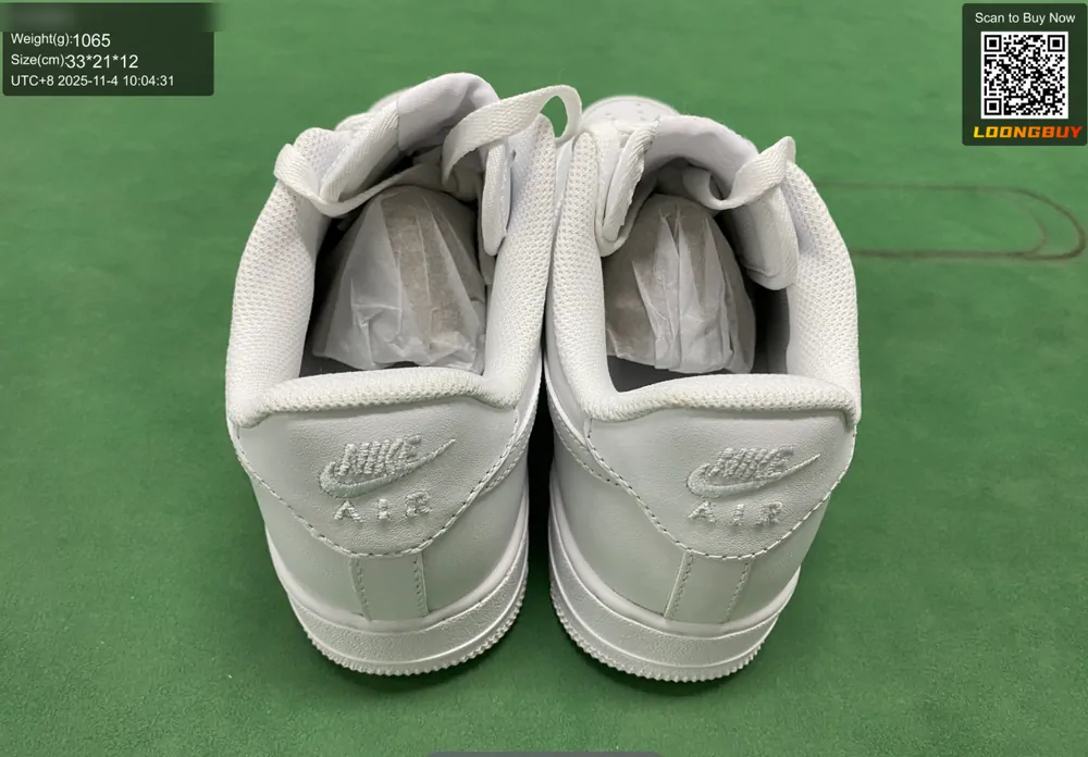 The back of a pair of white sneakers on the inspection bench showing the heels and collars